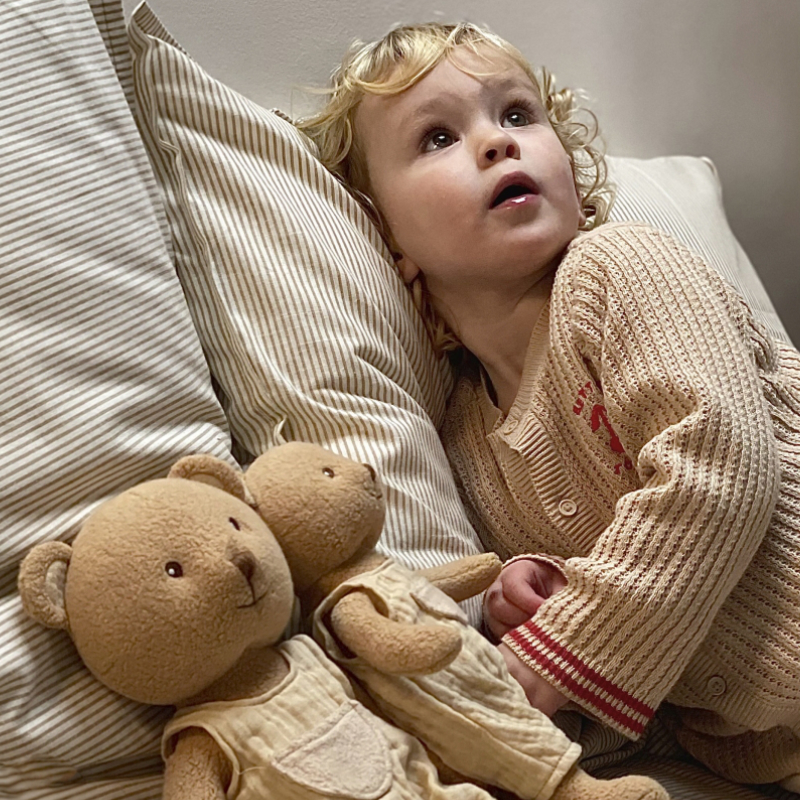Kind, Kleinkind, beige Cardigan, Teddybär, Plüschspielzeug