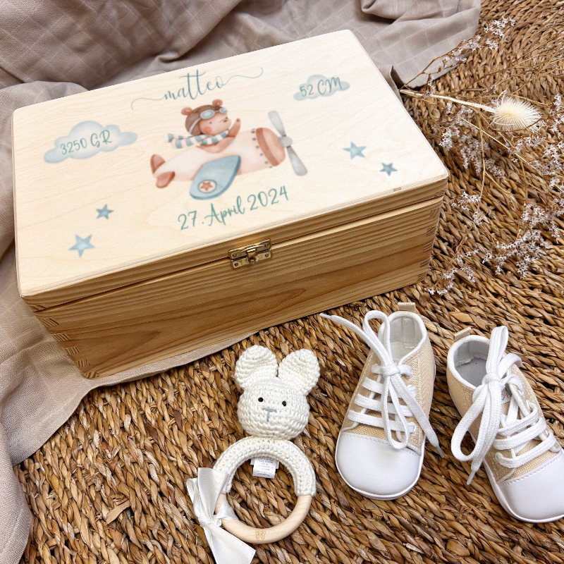 baby box, wooden box, pilot plane, knitted rattle, baby shoes