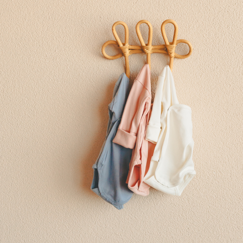Babybekleidung, aufhängbar, Pastellfarben, verknoteter Kleiderhaken, drei Kleidungsstücke