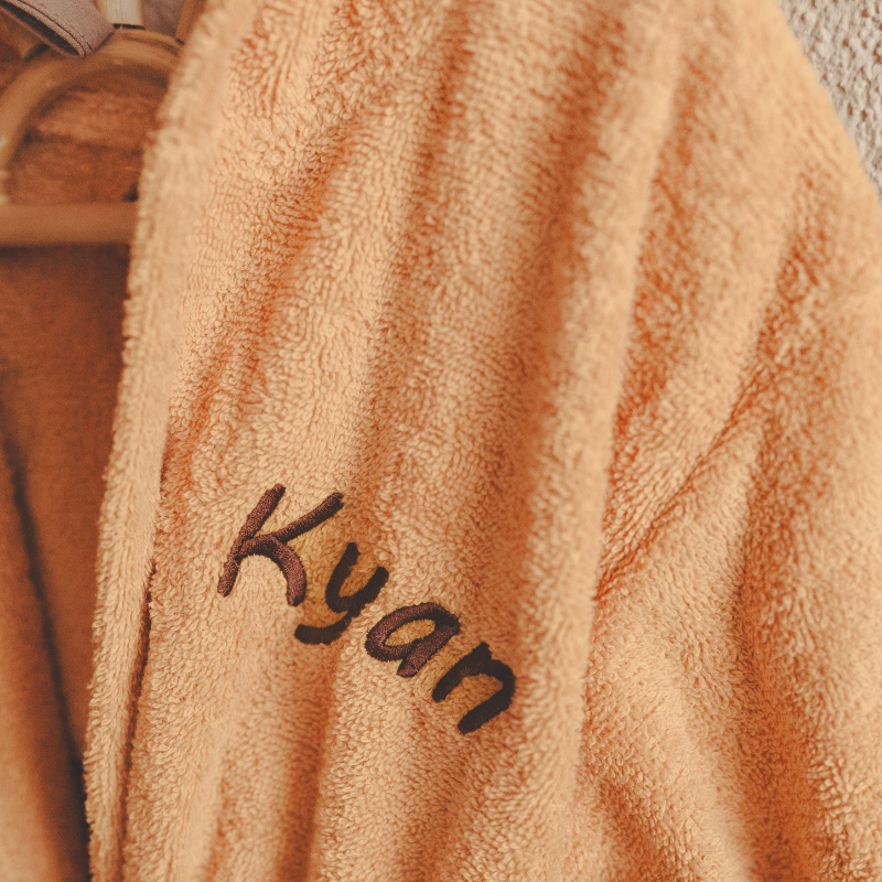 Bademantel, Teddy-Stoff, Pfirsichfarbe, eingestickter Text, k y a n