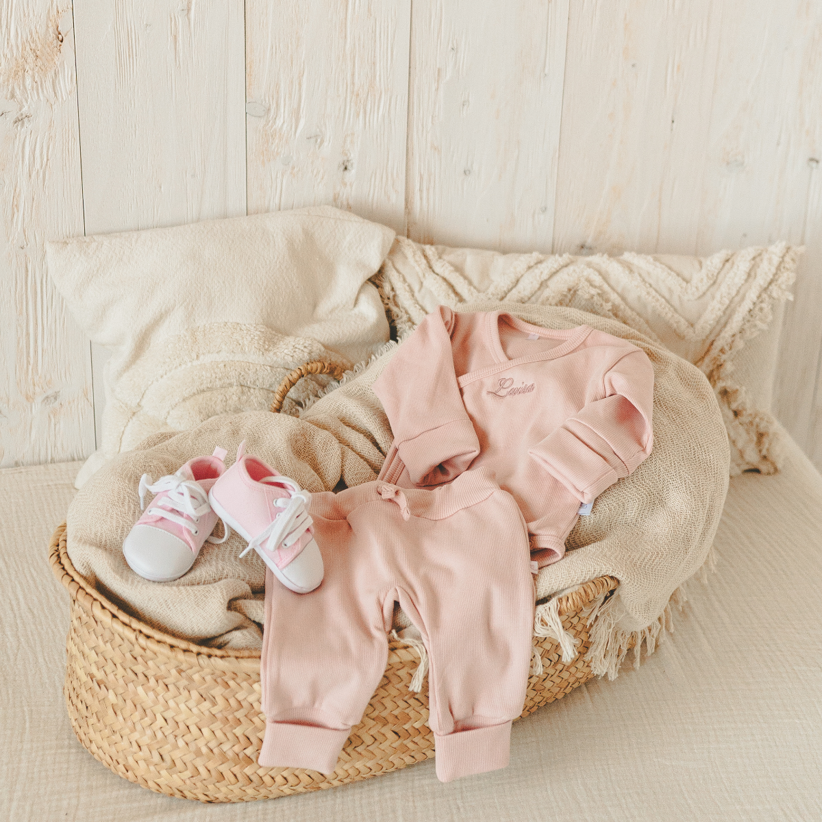 Babyoutfit, Rosa Overall, Babyschuhe, geflochtener Korb, weiche Decke